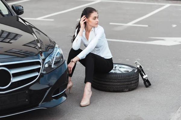 Woman sitting on tire — Stock Photo, Image