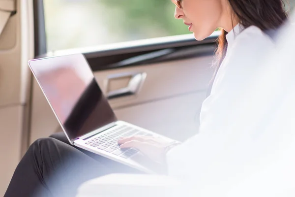 Mujer usando ordenador portátil en el coche — Foto de Stock