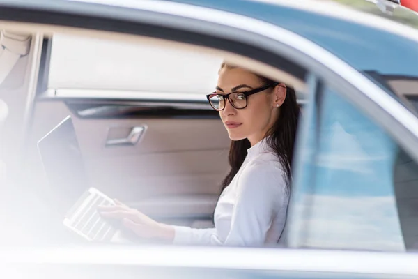 Mujer usando ordenador portátil en el coche —  Fotos de Stock