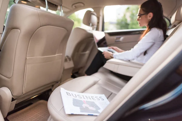Business newspaper in backseat of car — Stock Photo, Image