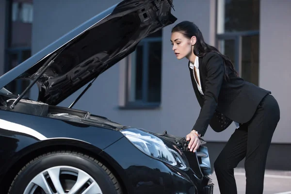 Nő keres a motorháztető az autó — Stock Fotó