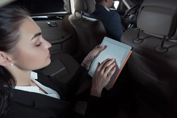 Mujer en el asiento del pasajero usando el comprimido — Foto de Stock