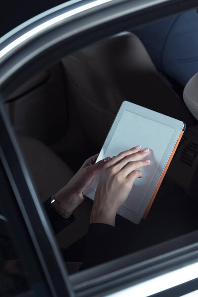 woman using digital tablet in car