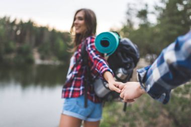 woman guiding boyfriend to wild lake clipart
