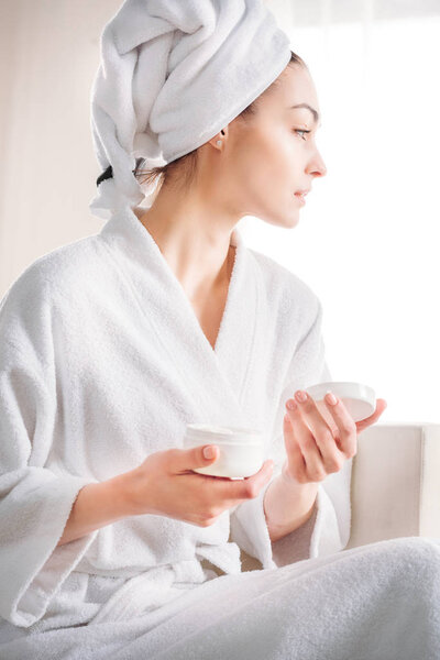 woman holding jar of cream