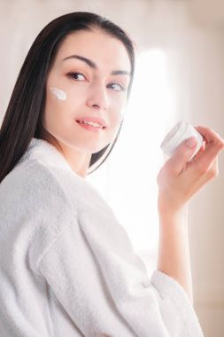 Yüz kremi uygulama bornoz kadında