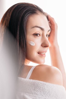 Young woman with cream applied to face clipart