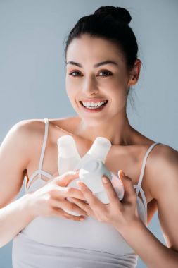 Kozmetik kapsayıcılar tutan gülümseyen kadın