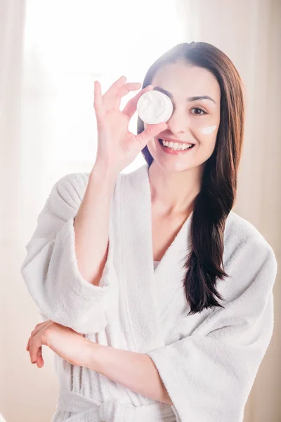 Mujer mostrando frasco abierto de crema — Foto de Stock