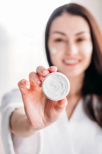 Woman showing open jar of cream — Stock Photo, Image