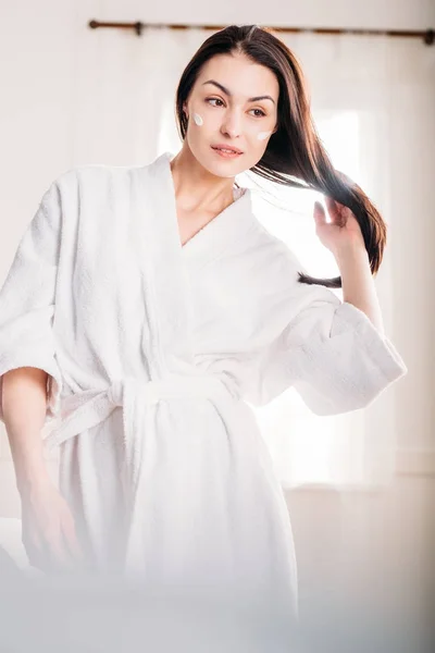 Woman in bathrobe with cream on face — Free Stock Photo