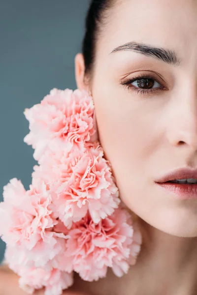 Jovem posando com cravos rosa — Fotografia de Stock