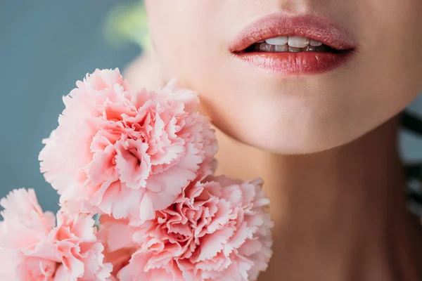 Frau mit rosa Nelken — Stockfoto