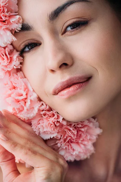 Улыбающаяся женщина позирует с гвоздичными цветами — стоковое фото