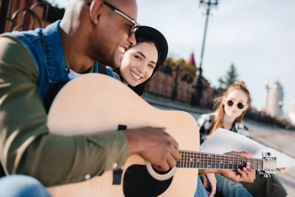 Multicultural friends with guitar — Stock Photo, Image