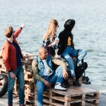 Multiculturele vrienden rustend op de pier