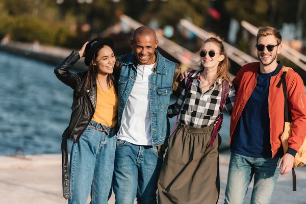 Multicultural friends walking on pier — Stock Photo, Image