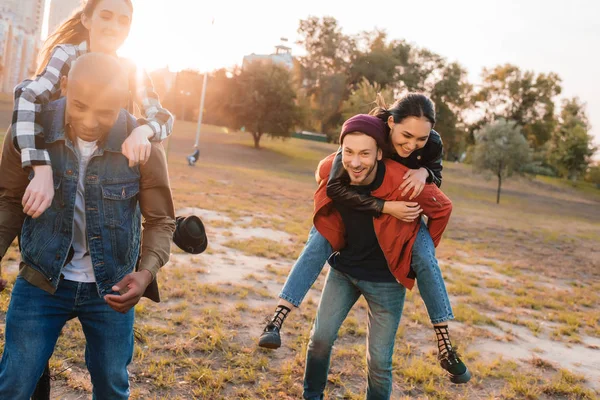 Glückliche Paare huckepack zusammen — Stockfoto