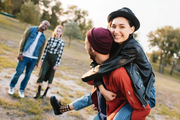 Pareja piggybacking en parque — Foto de Stock