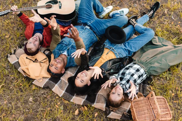 Mångkulturella vänner vilar på filt tillsammans — Stockfoto