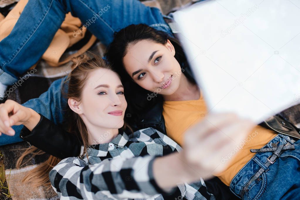 multicultural women taking selfie on tablet