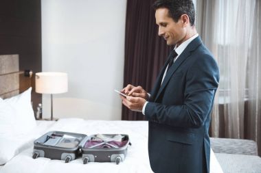 Otel odasında telefon kullanarak iş adamı