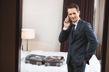 Otel odasında telefonda konuşan işadamı