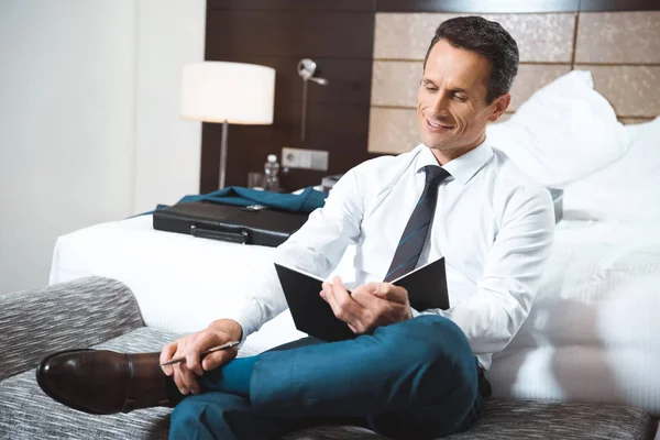 Hombre de negocios escribiendo en cuaderno — Foto de Stock