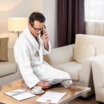 Businessman in bathrobe talking on phone