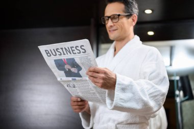 Businessman in bathrobe reading newspaper clipart