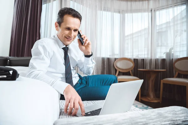 Biznesmen na telefon za pomocą laptopa — Zdjęcie stockowe