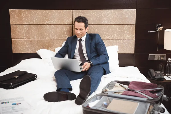 在床上使用笔记本电脑的商人 — 图库照片