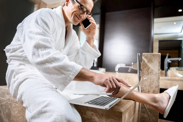 Pengusaha dalam mantel mandi bekerja dengan perangkat — Stok Foto