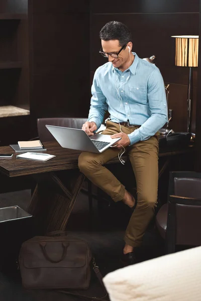 Hombre de negocios en auriculares con ordenador portátil —  Fotos de Stock