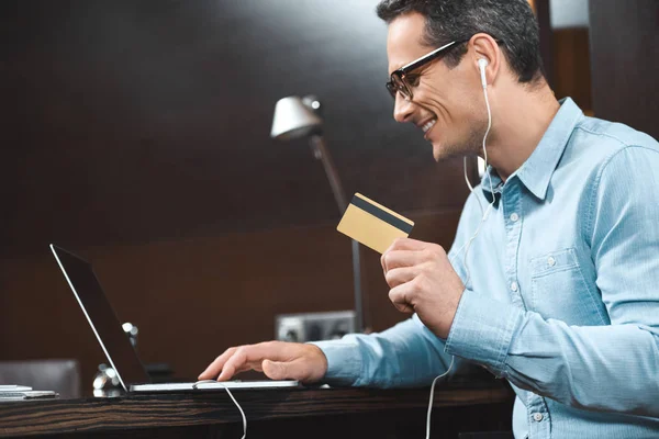 Businessman holding credit card and laptop — Stock Photo, Image