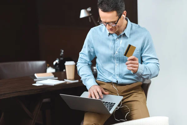 Hombre de negocios con tarjeta de crédito y portátil — Foto de Stock