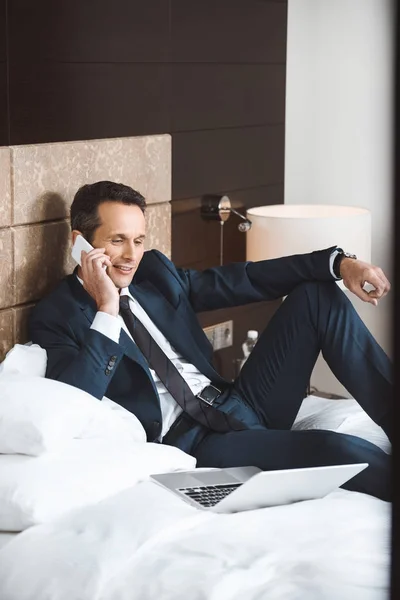 Homem de negócios na cama falando ao telefone — Fotografia de Stock