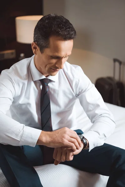 Businessman looking at watch — Free Stock Photo