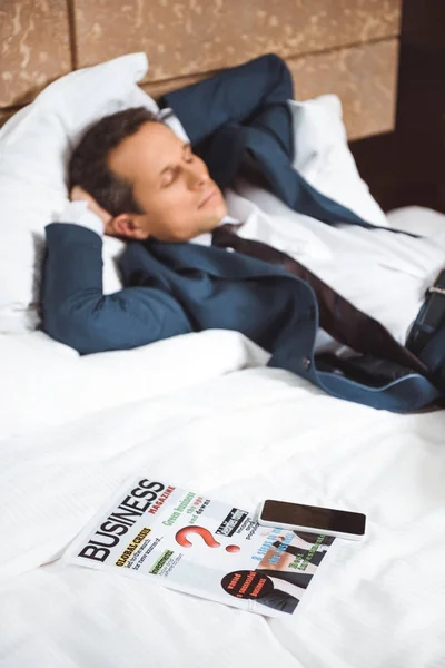 Jornal de negócios na cama do hotel — Fotografia de Stock
