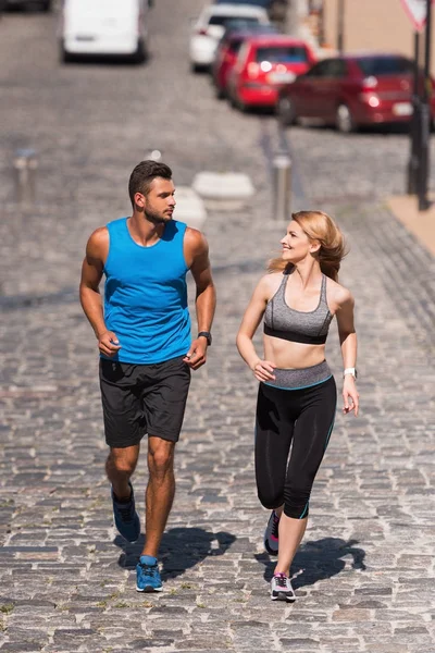 Sportswoman and sportsman jogging in city — Stock Photo, Image