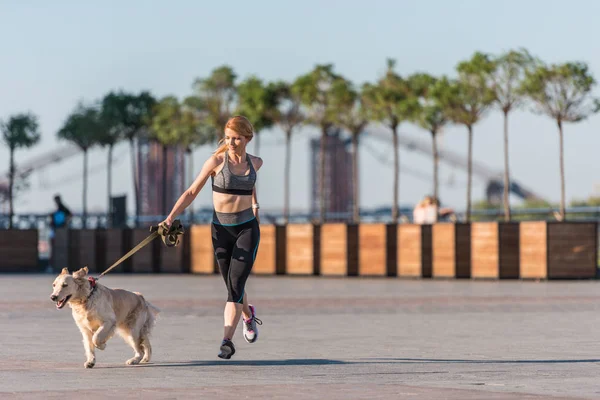 Olahragawan wanita joging dengan anjing — Stok Foto
