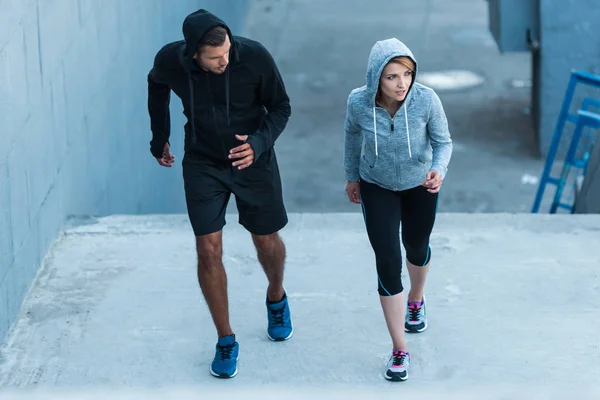 Sportswoman and sportsman jogging on stairs — Stock Photo, Image