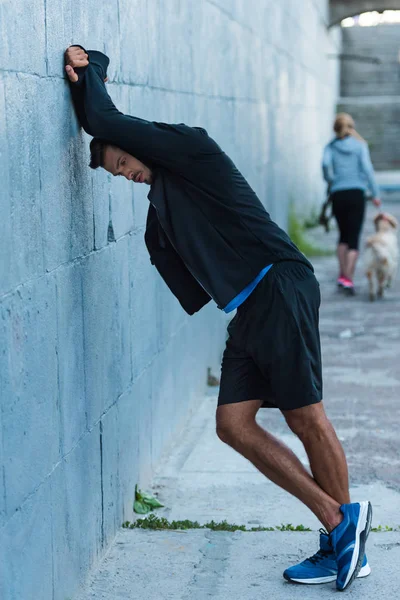 Deportista de pie en la pared — Foto de Stock