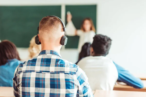 Estudiante escuchando música en conferencia — Foto de Stock