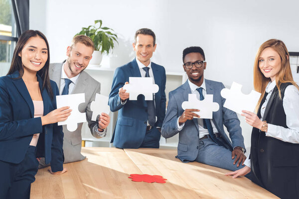 businesspeople holding puzzle pieces