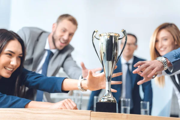 Businesspeople trying to catch champion cup — Stock Photo, Image