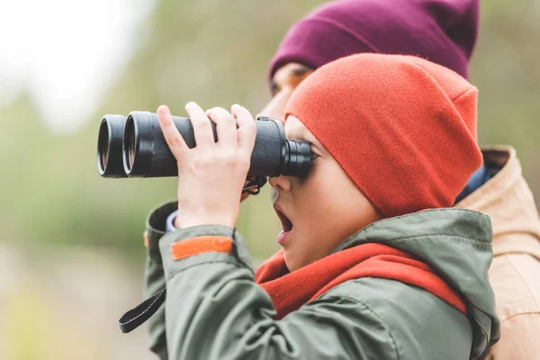 Jongen kijkt door een verrekijker — Stockfoto