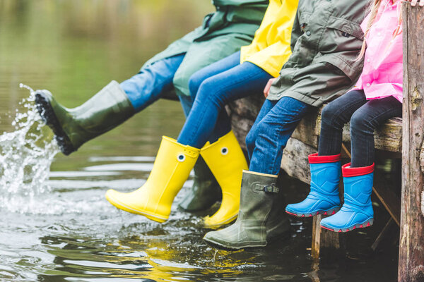 family sitting on wooden bridge