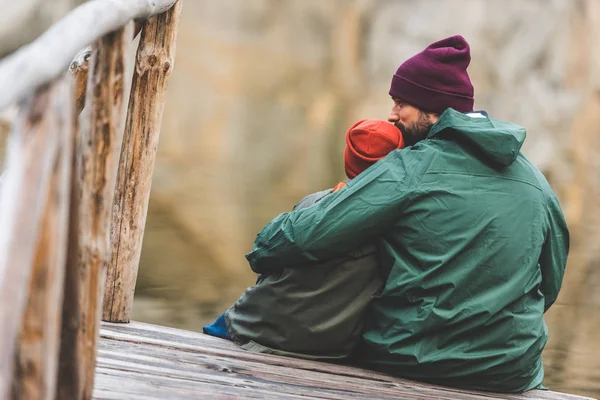 Padre e figlio seduti su un ponte di legno — Foto Stock