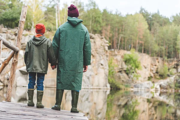 Father and son standing on bridge in forest — Stock Photo, Image